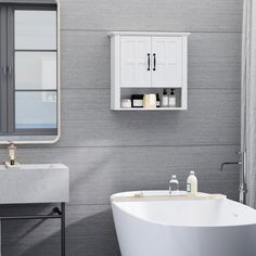 a white bath tub sitting under a bathroom mirror