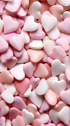 many pink and white hearts are scattered together