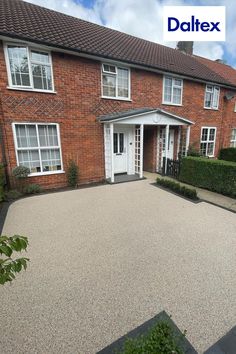 an empty driveway in front of a brick house