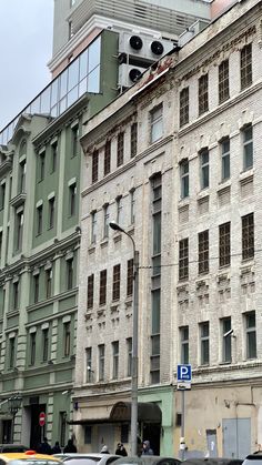 an old building with cars parked on the side of it in front of other buildings