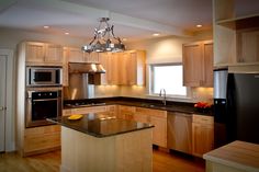 a kitchen with wooden cabinets and black counter tops