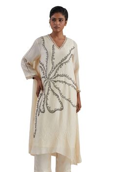 Off white kaftan hand embroidered with flower motif, asymmetric hem and sheer scalloped border detailing on neck and cuffs. Paired with a flared pant with sheer border on hem and contrasting line on sides. - Aza Fashions Elegant V-neck Kaftan With Embroidered Neckline, Spring V-neck Kaftan With Chikankari Embroidery, Elegant Floral Embroidered V-neck Kaftan, White V-neck Embellished Kaftan, Elegant Kaftan With Chikankari Embroidery And V-neck, Elegant V-neck Kaftan With Chikankari Embroidery, Asymmetric Pants, Kaftan Set, Hand Embroidered Flower