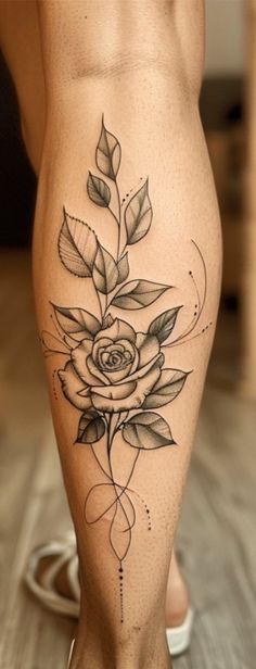 a woman's leg with a rose tattoo on it