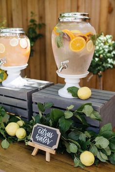 there are lemons and water in the vases on the table with chalkboard signs