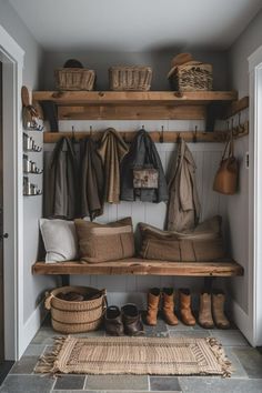 an entryway with lots of coats and boots hanging on the wall next to it