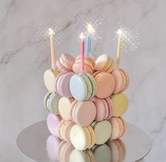 a cake made out of macaroons with two lit candles