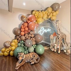 an animal themed party with balloons and giraffes on the floor in front of it