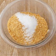 a glass bowl filled with sugar on top of a wooden table