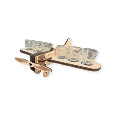 two wooden trays with glasses on them and one holding an object in the shape of a plane