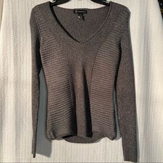 - Size Small Womens - Rayon, Acrylic, Nylon, Polyester, & Metallic Material - Very Stretchy & Fitted!! - Machine Washable - Pit To Pit Measures 15” - Top Length Is 24.5” - Sleeve Length Is 26” Never Worn And New With Tags! Comes From A Smoke Free Home! Silver Stretch Top For Fall, Silver V-neck Top For Fall, Fall Season Silver V-neck Top, Gray V-neck Sweater For Loungewear, Deep V Neck Sweater, Gray Knitted V-neck Outerwear, Gray Knit V-neck Outerwear, Gray Textured Knit V-neck Sweater, Luxury Gray V-neck Sweater