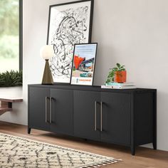 a living room with a black cabinet and pictures on the wall