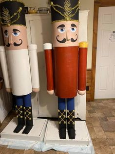 two wooden nutcrackers standing next to each other in front of a door