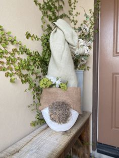 a potted plant sitting on top of a wooden bench next to a bag filled with dirt