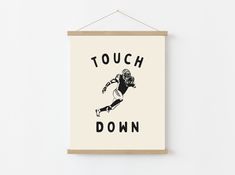 a poster hanging on the wall that says touch down with a football player in black and white