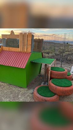 an outdoor play area with green grass and red roof