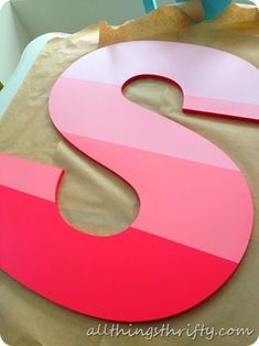 there is a large pink and red letter s on the table