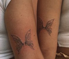 two people with tattoos on their legs, one is holding the other's leg