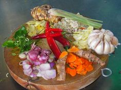 a wooden cutting board topped with lots of different types of vegetables on top of it