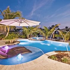 an outdoor swimming pool surrounded by palm trees