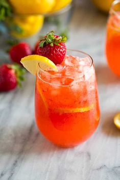 a close up of a drink with lemons and strawberries