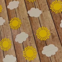 paper clouds and sun cut out on wood planks