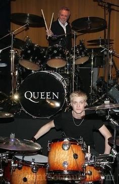 a man sitting in front of a drum set