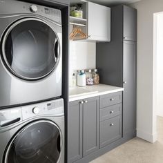 a washer and dryer sitting in a kitchen next to each other on top of cabinets