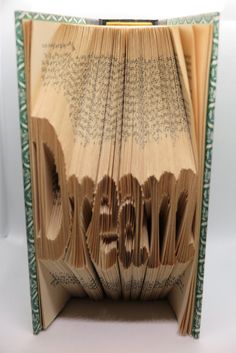 an open book with pages folded in the shape of numbers and letters that spell out 2013