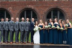 a group of people standing next to each other in front of a building with windows