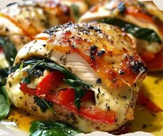 a plate with chicken, spinach and tomatoes on it