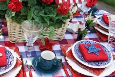 a table set with red, white and blue place settings for an outdoor dinner party