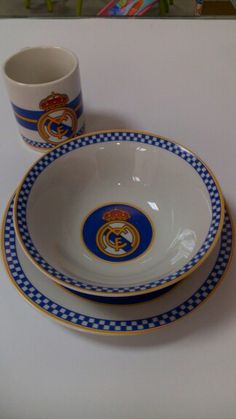 a white table with blue and gold plates and cups sitting on top of each other