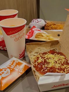 two takeout boxes filled with different types of food and drinks sitting on a table