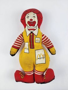 a mcdonald's stuffed toy is wearing red shoes and a yellow clown suit with white stripes