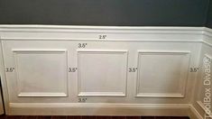 the wall is painted white and has five paneled doors on each side with measurements