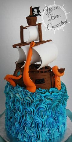 there is a cake that looks like a pirate ship on top of the ocean waves