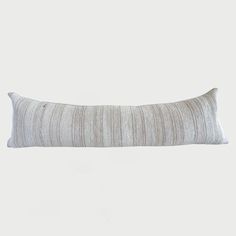 a white and grey striped pillow sitting on top of a table