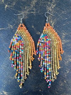 These beautiful earrings are handmade with ceramic beads. They are made by a group of artisans in Guatemala who are given fair wages and good working conditions. <3 To read more about the artisans please go to https://www.loscoloresdelatierra.com/pages/our-story The hooks are sterling silver.  The weight is 11g.  The beads are dyed with acrylic paint. Handmade Earthy Earrings For Festival, Artisan Beaded Earrings With Ear Wire, Artisan Multicolor Dangling Beads Earrings, Artisan Brown Earrings With Colorful Beads, Earthy Handmade Beaded Dangle Earrings, Bohemian Multicolor Wooden Bead Earrings, Earthy Handmade Multicolor Earrings, Multicolor Earthy Dangle Earrings, Earthy Multicolor Dangle Earrings