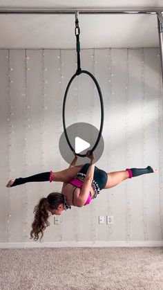 a woman is doing aerial acrobatics on a hoop