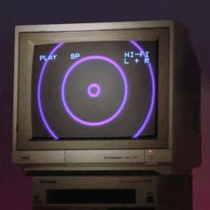 an old computer with a play sp on it's screen and purple circles around the screen