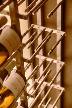 several bottles of wine are lined up in a rack with metal bars on the sides