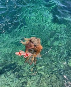 a woman swimming in the ocean with her hand out to touch the water's surface