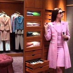 a woman standing in front of a closet filled with clothes