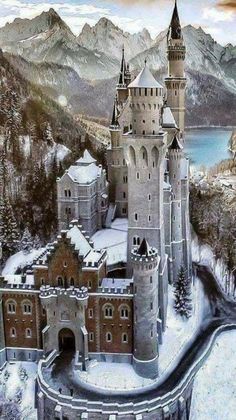 an old castle with snow on the ground and mountains in the background