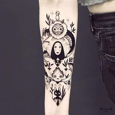 a woman's arm with tattoos on it and an owl in the middle, surrounded by other animals