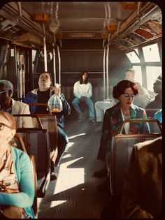 many people are sitting on the bus and one is holding a wine glass in her hand