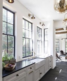 a large kitchen with white cabinets and black counter tops, along with an island in the middle