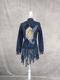 a denim jacket with fringes and patches on the back, sitting on a mannequin's head