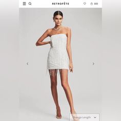 a white dress with fringes on the bottom and one side that has an image of a woman in it