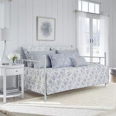 a bedroom with white walls and blue floral bedding